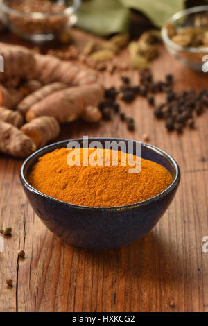 Gemahlener Kurkuma-Pulver in einer Schüssel auf hölzernen Hintergrund. Gesunde Würze. Stockfoto