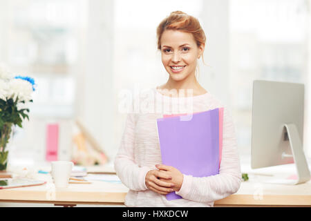 Attraktive Geschäftsfrau mit Ordnern in Händen Stockfoto