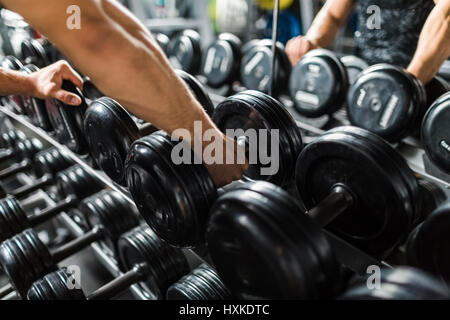 Hand, die Gewichte von Rack abholen Stockfoto