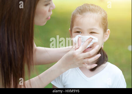 Mutter Tochter ihre Nase an draußen im Park Putzen zu helfen. Familie outdoor-Lifestyle. Stockfoto