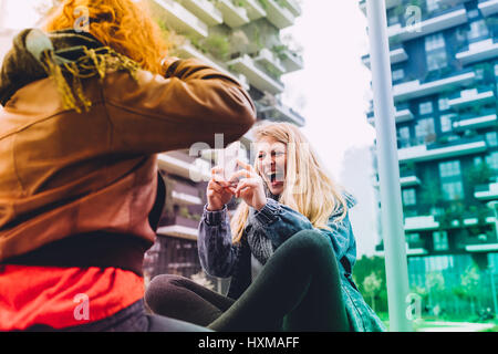 Zwei junge Frauen, die mit smart phone im freien fotografieren - Technik, soziales Netzwerk, Kommunikations-Konzept Stockfoto