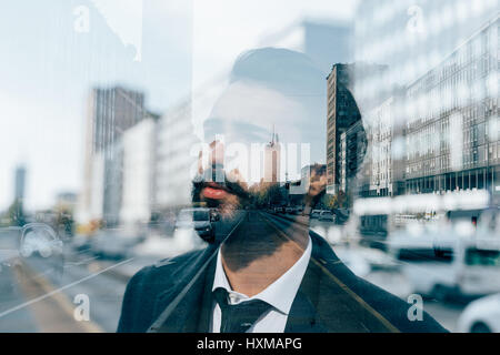 Doppelbelichtung von kaukasischen bärtigen Jüngling im Freien mit Blick auf nachdenklich - kreativ, nachdenklich, ernst Konzept Stockfoto