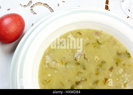 Ostern-Suppe und rotes Ei auf weiße Tischdecke Stockfoto