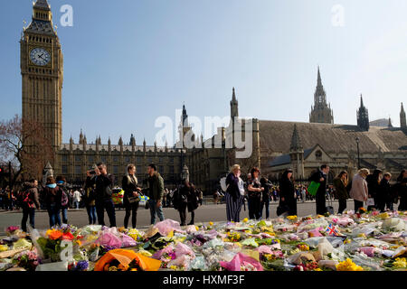 Westminster, London, UK. 27. März 2017. Menschen betrachten die floral Tribute in Parliament Square in den Terror Attac getöteten erinnern links Stockfoto