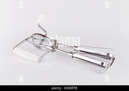 Handmixer auf einer weißen Fläche. Manuellen Schneebesen isoliert auf weißem Hintergrund. Stockfoto