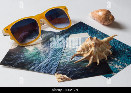Gelbe Sonnenbrille, Shell und Bilder mit dem Bild des Meeres auf weiße Fläche Stockfoto