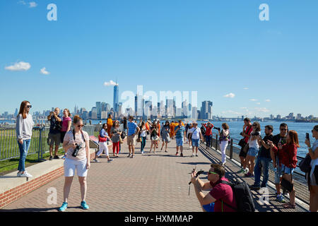 Menschen und Touristen fotografieren mit Skyline von New York City an einem sonnigen Tag in New York. Stockfoto