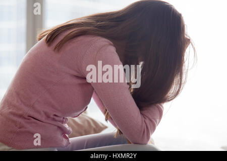 Junge frustriert Frau sitzt allein, traurig und müde, habend prob Stockfoto