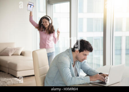 Mann mit Laptop-Computer, Frau Musik hören auf Tablet indoo Stockfoto