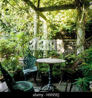 Tisch und Stühle unter Pergola. Stockfoto