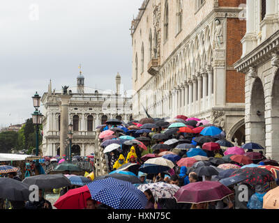 Venedig im Regen mit Touristen tragen Regenschirme in der Nähe von Dogenpalast Stockfoto