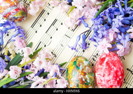 Bemalte Ostereier und Hyazinthe Blumen auf Notenblätter Stockfoto