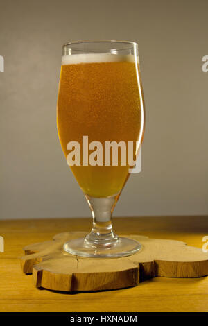 Volles Glas Bier auf einem grauen Hintergrund Stockfoto