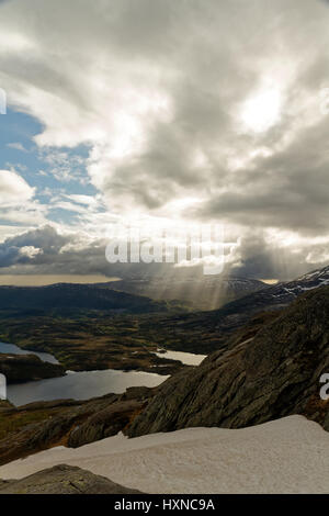 Strahlen von Licht, das durch Wolken in einer bergigen Landschaft im Norden von Norwegen Stockfoto