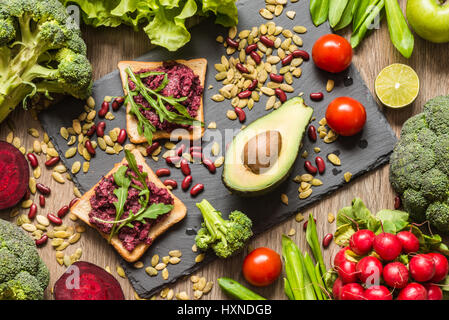 Gesunde vegane Ernährung. Sandwiches und frisches Gemüse auf hölzernen Hintergrund. Stockfoto