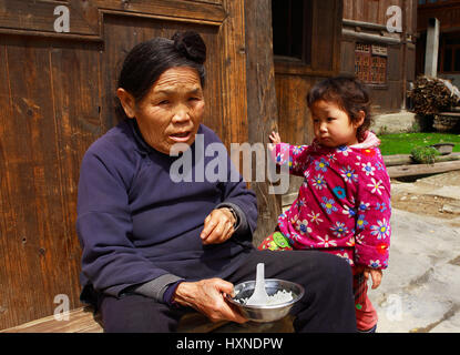 GUIZHOU PROVINZ; CHINA - 8. APRIL: Dong ethnische alte RSS-Feeds Kind von drei Jahren von Haus in Zhaoxing Dong Dorf, 8. April; 2010. Liping County. G Stockfoto