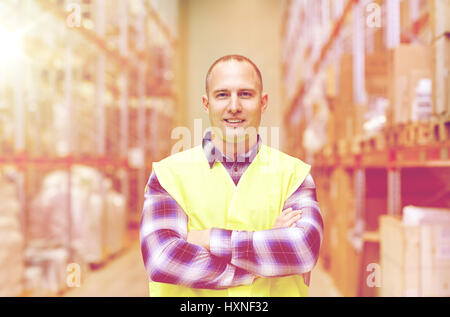 glücklicher Mensch in reflektierende Warnweste im Lager Stockfoto