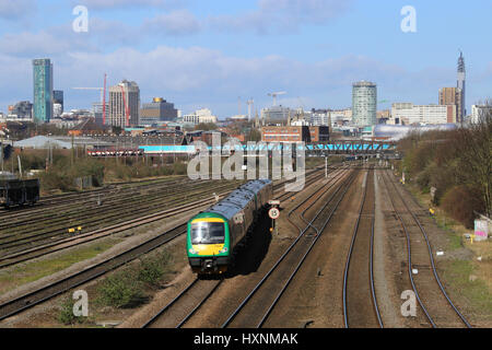 Diesel-Personenzug der Baureihe 170, der aus dem Stadtzentrum von Birmingham, West Midlands, England und Großbritannien fährt, mit Blick auf die Skyline des Stadtzentrums. Stockfoto