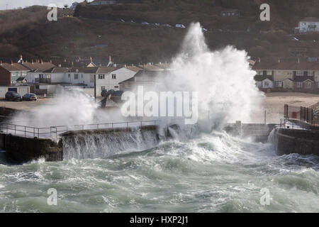 Wellen brechen über die Hafenmauer in Portreath bei einem Wintersturm Stockfoto