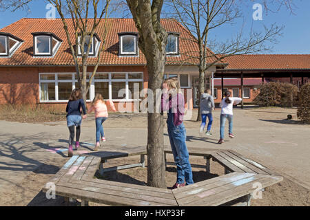 Kinder in der Grundschule spielen verstecken und suchen in Pause Stockfoto