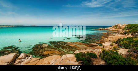 Wilden felsigen Strand mit türkisfarbenem kristallklarem Wasser und großen Steinen in Vourvourou, Sithonia, Griechenland Stockfoto