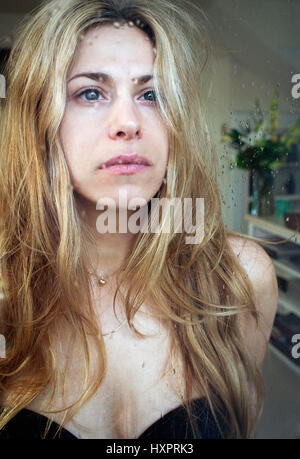 Eine Frau schaut aus dem Fenster. Stockfoto