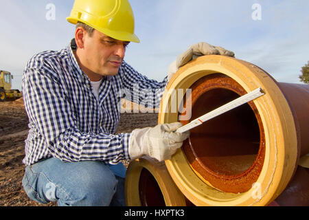 Bauarbeiter arbeitet beim Bauarbeiter Arbeitet Mit Rohr-Rohr Stockfoto