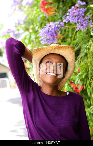 Porträt von schöne junge schwarze Frau mit Hut steht im freien Stockfoto