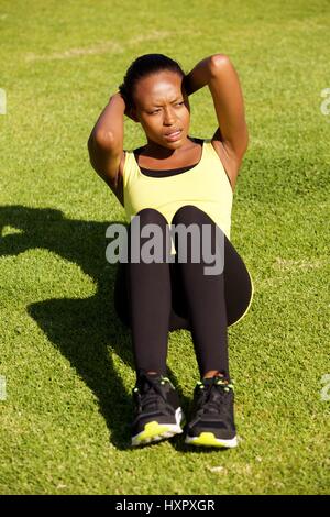 Porträt von Fit junge afrikanische Frau Bauch Crunch-Übungen im freien Stockfoto