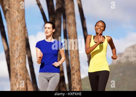 Porträt zweier junger Frauen, die Joggen zusammen draußen in der Natur Stockfoto