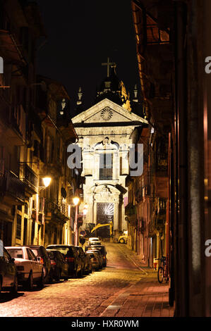 Nacht-Straßenszene in Porto, Portugal, Blick über Rua da Sao Miguel, die Kirche Igreja Paroquial da Vitoria Stockfoto