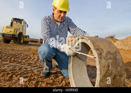 Bauarbeiter arbeitet beim Bauarbeiter Arbeitet Mit Rohr-Rohr Stockfoto