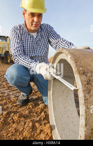 Bauarbeiter arbeitet beim Bauarbeiter Arbeitet Mit Rohr-Rohr Stockfoto