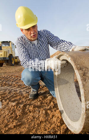 Bauarbeiter arbeitet beim Bauarbeiter Arbeitet Mit Rohr-Rohr Stockfoto