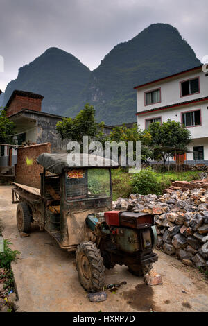 Yangshuo, Guangxi, China - 29. März 2010: Abgenutzte Vintage Bauernhof Traktor steht unter freiem Himmel in einem Bauerndorf zwischen den Karst Hügeln von Guilin ein Stockfoto