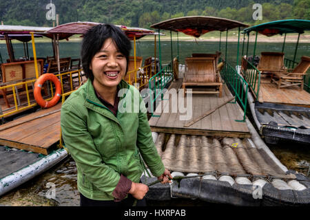 Yang Di Dorf, Yangshuo, Guangxi, China - 29. März 2010: chinesische Schiffer Frauen Lijiang-Fluss, Mädchen moors Bambus-Floß und lächelnd Guangxi Zhuang Aut Stockfoto