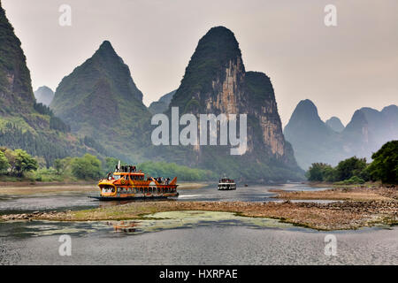 Yangshuo, Guangxi, China - 29. März 2010: Kreuzfahrtschiff voller Touristen reisen die herrliche Panoramastraße entlang dem Lijiang-Fluss von Guilin t Stockfoto