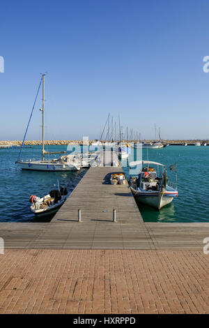 Holzsteg am Yachthafen in dem Fischerdorf Zygi, Zypern.  Frühling gedreht an einem sonnigen Nachmittag. Stockfoto