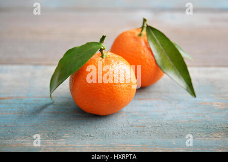 Mandarinen mit Blättern auf hölzernen Hintergrund closeup Stockfoto