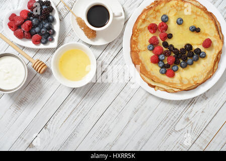 Pfannkuchen mit frischen Beeren und Honig auf hölzernen Hintergrund Stockfoto