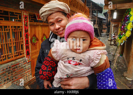 Zengchong Dorf, Guizhou, China - 13. April 2010: die ländliche Familie von Südost-Asien, der Vater hält das Kind in ihren Armen, 13. April 2010. Zengch Stockfoto