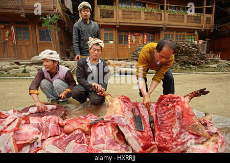 Provinz GUIZHOU, CHINA - APRIL 12: Chinesische Bauern, Landwirte, Schweinefleisch wird auf einer Landstraße in Zengchong Dorf, Provinz Guizhou, 12. April 2010 geschnitten. Stockfoto