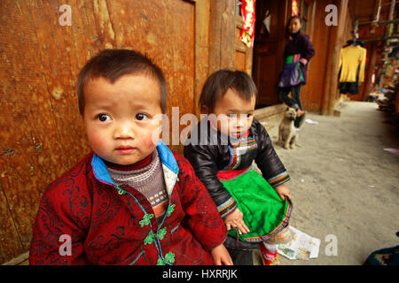 Zengchong Dorf, Guizhou, China - 12. April 2010: ländliche asiatischen Kind 3 Jahre alt, sitzen auf dem Hof des Holzhauses, Zengchong Dong ethnische Minderheit Stockfoto