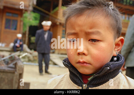 Zengchong Dorf, Guizhou, China - 12. April 2010: ländliche Gebiete im Südwesten Chinas, ein Junge 8 Jahre ist verärgert Tränen im Gesicht, Zengchong Dong ethnische Stockfoto