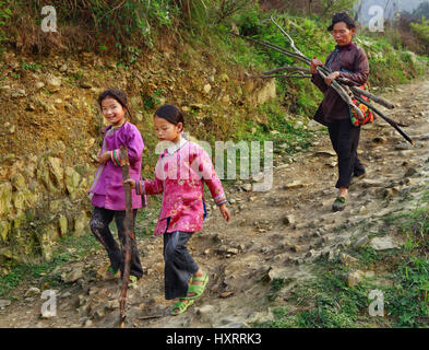 Zengchong Dorf, Guizhou, China - 11. April 2010: chinesische Familie stammt den felsigen Bergweg, die beiden Mädchen sind 8 Jahre alt, und ihre Mutter, Stockfoto