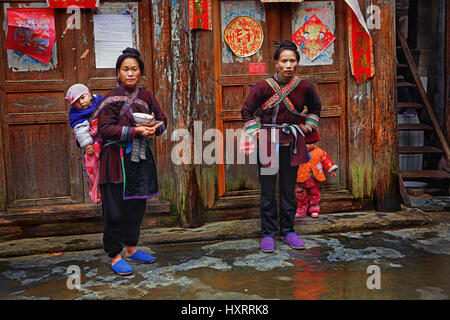 Zengchong Dorf, Guizhou, China - 13. April 2010: asiatische Frauen aus dem chinesischen, tragen Kind auf Rücken, Dong, Zengchong-Dong min Menschen in Tracht Stockfoto