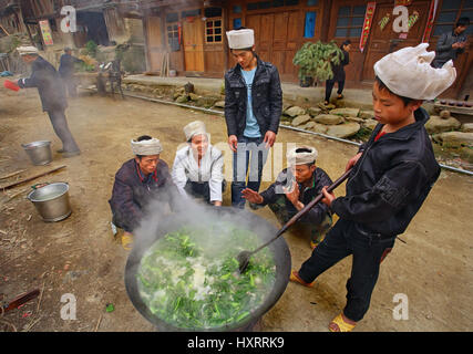 Zengchong Dorf, Guizhou, China - 12. April 2010: chinesische Dorfbewohner, Bauern, Bauern kochen Suppe in einem großen Topf, im Freien, 12. April 2010. Asien, ländliche Stockfoto