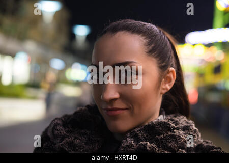 Junge und schöne Mädchen mit bunten Reflexion der Nacht leuchtet auf Hintergrund. Nacht-Stadtleben Stockfoto