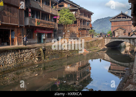 Zhaoxing Dong Dorf, Guizhou Provinz, China - 8. April 2010: Ländliche Fluss mit Kopfsteinpflaster Wasser umgeben von Holzhütten, Dorf Minderheit. Stockfoto