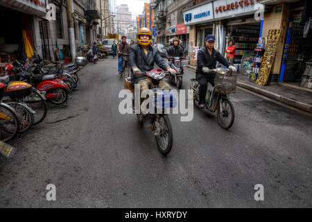 Shanghai, China - 20. April 2010: Verkehr auf den Straßen von asiatischen Städten, Zweirad-Verkehr, mit Motorrädern, Mopeds, Motorräder, Motorroller Stockfoto